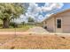 Spacious backyard with patio, beautiful landscaping, mature trees, string lights, and room for outdoor activities at 1053 Yarmouth St, Port Charlotte, FL 33952