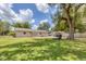 Large backyard with ample green space, mature trees, and privacy fence, perfect for outdoor activities at 1053 Yarmouth St, Port Charlotte, FL 33952