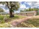 Spacious backyard showcasing mature trees, well-maintained lawn, and a patio, great for outdoor enjoyment at 1053 Yarmouth St, Port Charlotte, FL 33952