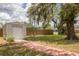Backyard with shed, greenery, and trees offering ample space for storage and outdoor activities at 1053 Yarmouth St, Port Charlotte, FL 33952