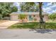 Charming home with a well-manicured lawn, complemented by tropical landscaping and a light blue front door at 1053 Yarmouth St, Port Charlotte, FL 33952