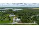 Aerial view showcasing the property's boundaries, including a spacious home, metal building, and serene lake at 10810 Wheeler Pl, Punta Gorda, FL 33950