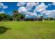 Large backyard featuring a well-maintained lawn and screened-in pool area, perfect for outdoor activities at 10810 Wheeler Pl, Punta Gorda, FL 33950