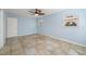 Cozy bedroom with tile floors, ceiling fan, natural light, and blue walls at 10810 Wheeler Pl, Punta Gorda, FL 33950
