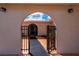 Welcoming arched courtyard entrance with tiled walkway and decorative iron gate at 10810 Wheeler Pl, Punta Gorda, FL 33950