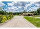 Long, well-maintained driveway to a ranch home features a meticulously manicured lawn and mature trees at 10810 Wheeler Pl, Punta Gorda, FL 33950