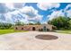 Exterior view of a home featuring a circular driveway, columned porch, and lush landscaping at 10810 Wheeler Pl, Punta Gorda, FL 33950