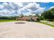 A long circular driveway leads up to a charming single-story home with a beige facade at 10810 Wheeler Pl, Punta Gorda, FL 33950