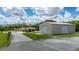 View of the home with a metal building, and lush lawns under a blue sky at 10810 Wheeler Pl, Punta Gorda, FL 33950
