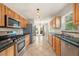Bright kitchen featuring wood cabinets, stainless steel appliances, granite countertops, and tile flooring at 10810 Wheeler Pl, Punta Gorda, FL 33950