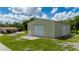 Large metal building with two roll-up doors, complemented by a home, and green lawn at 10810 Wheeler Pl, Punta Gorda, FL 33950