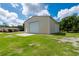 Exterior shot of a large metal building with a roll-up door and green lawn at 10810 Wheeler Pl, Punta Gorda, FL 33950