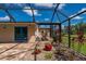 Enclosed patio area with brick flooring, landscaping, and entry to the main house with bright blue double doors at 10810 Wheeler Pl, Punta Gorda, FL 33950