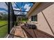 Screened-in patio with brick pavers, landscaping, and mulch along the side of the house at 10810 Wheeler Pl, Punta Gorda, FL 33950