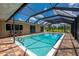 Beautiful screened-in pool featuring brick flooring and an exterior view of the lawn and trees at 10810 Wheeler Pl, Punta Gorda, FL 33950