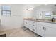 Bright bathroom featuring a double sink vanity with granite countertop, enhanced by modern fixtures at 11105 Balfour E St, Venice, FL 34293