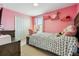 Cozy bedroom in pink featuring a comfortable bed, vanity, and ample storage space at 11105 Balfour E St, Venice, FL 34293