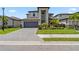 Stunning two-story home featuring a well-manicured lawn and gray brick driveway leading to a spacious two-car garage at 11105 Balfour E St, Venice, FL 34293