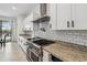 Gourmet kitchen with stainless steel appliances, granite counters, and white subway tile backsplash at 11105 Balfour E St, Venice, FL 34293