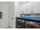 Well-organized laundry room with blue countertop, white cabinets and modern washer and dryer at 11105 Balfour E St, Venice, FL 34293