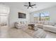 Bright living room with neutral décor, an oversized sectional sofa, and large windows at 11105 Balfour E St, Venice, FL 34293