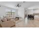 Bright living room features tile flooring, a ceiling fan and comfortable seating near the kitchen at 11105 Balfour E St, Venice, FL 34293