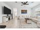 Cozy living room features neutral tones, a ceiling fan, and an entertainment center at 11105 Balfour E St, Venice, FL 34293