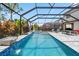 A screened-in pool and spa, featuring a waterfall and outdoor living space, enhances outdoor enjoyment at 11105 Balfour E St, Venice, FL 34293