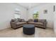 Cozy sitting area with two couches, ottoman, and a large window providing natural light on tile flooring at 11105 Balfour E St, Venice, FL 34293