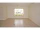 Bedroom featuring neutral tile flooring, large window, and a ceiling fan at 1128 Rum Cay Ct, Punta Gorda, FL 33950