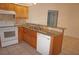 Traditional kitchen with stainless steel sink, white appliances, granite countertops, and light wood cabinets at 1128 Rum Cay Ct, Punta Gorda, FL 33950