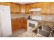 Cozy kitchen featuring stainless steel sink, granite countertops, white appliances, and wood cabinets at 1128 Rum Cay Ct, Punta Gorda, FL 33950