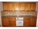 Kitchen showcasing warm wood cabinets, granite countertops, white appliances, and tile backsplash at 1128 Rum Cay Ct, Punta Gorda, FL 33950