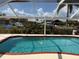 Inviting screened-in pool showcasing clear blue water with neighborhood canal views at 1128 Rum Cay Ct, Punta Gorda, FL 33950