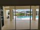 Lanai view of the pool and landscaping beyond the sliding glass doors at 1128 Rum Cay Ct, Punta Gorda, FL 33950