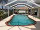 Beautiful screened-in backyard swimming pool with clear blue water and brick trim at 1128 Rum Cay Ct, Punta Gorda, FL 33950