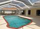 Screened-in pool area featuring a sparkling pool with brick border and access to the lanai at 1128 Rum Cay Ct, Punta Gorda, FL 33950