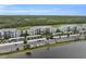 Aerial view of waterfront condos with carports and lush greenery along a serene lake at 14081 Heritage Landing Blvd # 214, Punta Gorda, FL 33955