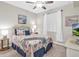 Bright bedroom with a ceiling fan, wicker headboard, side tables, and a large window at 14081 Heritage Landing Blvd # 214, Punta Gorda, FL 33955