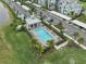 Aerial view of a community pool featuring a gazebo, lounge chairs, palm trees, and lush landscaping at 14081 Heritage Landing Blvd # 214, Punta Gorda, FL 33955