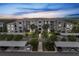 Exterior of a modern condo building featuring covered parking, balconies, and lush landscaping at 14081 Heritage Landing Blvd # 214, Punta Gorda, FL 33955