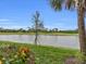 Scenic pond view with lush landscaping and clear blue sky at 14081 Heritage Landing Blvd # 214, Punta Gorda, FL 33955