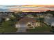 Charming single-story home featuring a well-maintained lawn, attached garage, and tropical landscaping under a beautiful sunset at 1605 Palace Ct, Punta Gorda, FL 33980