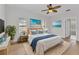 Tranquil main bedroom featuring a comfortable bed, beach themed artwork, ceiling fan and wood-look flooring at 1605 Palace Ct, Punta Gorda, FL 33980