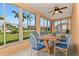 Bright sunroom with large windows showcasing a lush green lawn and a dining table with comfortable seating at 1605 Palace Ct, Punta Gorda, FL 33980
