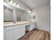 Spacious bathroom featuring double vanity with white cabinets and hardwood floors at 16848 Canopy Garden Dr, Port Charlotte, FL 33953