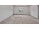 Bedroom with gray carpet and neutral walls, with a window overlooking the neighborhood at 16848 Canopy Garden Dr, Port Charlotte, FL 33953