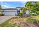 Beautiful one-story home with a two-car garage, well-manicured lawn, and stone accents at 16848 Canopy Garden Dr, Port Charlotte, FL 33953