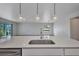Kitchen island with stainless steel sink and faucet with view of living room at 16848 Canopy Garden Dr, Port Charlotte, FL 33953