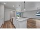 Modern kitchen island with sink and pendant lighting, opens to the living area at 16848 Canopy Garden Dr, Port Charlotte, FL 33953